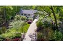 Aerial view of a brick home with lush greenery, manicured lawns, and a long driveway at 2105 White Oak Rd, Raleigh, NC 27608