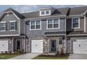 Charming townhome showcasing stone accents, individual garages, and appealing curb appeal with manicured landscaping at 2112 Willow Gln Dr, Graham, NC 27253