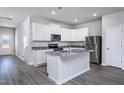 Bright kitchen with white cabinets, stainless steel appliances, granite countertops and new wood floors at 2112 Willow Gln Dr, Graham, NC 27253