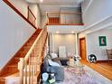 Sun-drenched living room with hardwood floors, staircase, and loft overlooking the space at 212 Columbia W Pl, Chapel Hill, NC 27516