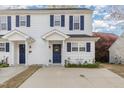 Charming two-story townhouse featuring white siding, navy shutters, and a well-maintained front yard at 2225 Whistling Straits Way, Raleigh, NC 27604