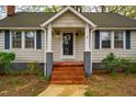 A welcoming front entrance with brick steps, classic white columns, and a decorative wreath on the glass front door at 2422 S Alston Ave, Durham, NC 27713
