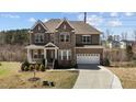 Charming two-story home boasts a stone and brick facade, attached two car garage, and a well-manicured front yard at 2713 Tunstall Grove Dr, Apex, NC 27523