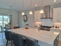 Open-concept kitchen featuring a large island, stainless steel appliances, and modern pendant lighting at 2915 Cox Mill Rd, Sanford, NC 27332