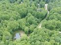 Aerial view of a house nestled among lush green trees, showcasing its secluded and peaceful setting at 3014 Split Wood Ct, Oxford, NC 27565