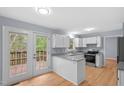 White kitchen with granite countertops, stainless steel appliances, and access to a deck at 302 Rushingwater Dr, Cary, NC 27513