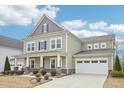 Charming two-story home with green siding, a covered front porch, and a two-car garage at 3348 Table Mountain Pine Dr, Raleigh, NC 27616