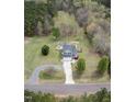 Stunning aerial view of the home showcasing its spacious lot, circular driveway, and wooded surroundings at 3690 Mabel Ln, Stem, NC 27581