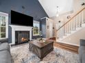 Cozy living room with a fireplace, large windows, and stylish decor at 3690 Mabel Ln, Stem, NC 27581