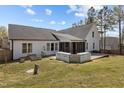 Expansive backyard featuring a wooden deck, covered porch, and ample space for outdoor activities at 381 Heart Pine Dr, Wendell, NC 27591