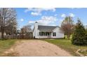 A cozy one-story home with a white exterior, a gray roof, a gravel driveway, and a well-manicured lawn at 40 Hill Rd, Franklinton, NC 27525