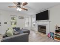 Inviting living room with a fireplace, mounted TV, ceiling fan, and a comfortable sectional sofa with throw pillows at 40 Hill Rd, Franklinton, NC 27525