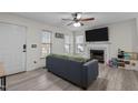 Bright living room featuring a fireplace, mounted television, ceiling fan, and a comfy gray sectional sofa at 40 Hill Rd, Franklinton, NC 27525