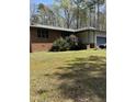 A brick house with an attached garage and green lawn on a sunny day at 4001 W Antioch Dr, Oxford, NC 27565