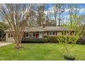 Charming single-story house with a lush green lawn, mature tree, and quaint red window shutters at 407 W Cornwall Rd, Cary, NC 27511