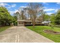 Well-kept ranch-style house with a long driveway and landscaping, showcasing suburban appeal at 407 W Cornwall Rd, Cary, NC 27511