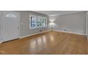 Bright, open living room featuring hardwood floors, large windows and a welcoming front door at 407 W Cornwall Rd, Cary, NC 27511