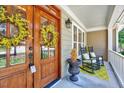 Close-up of a charming front porch with rocking chairs, double-door entrance, and decorative accents at 44 Grandwood Cir, Durham, NC 27712