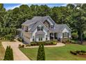 Beautiful home with a manicured lawn, mature trees and a circular driveway providing ample parking at 45 Calabria Ct, Clayton, NC 27527