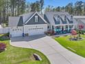 A beautiful two-story home with a three-car garage and a long, curved driveway at 49 Everwood Dr, Four Oaks, NC 27524