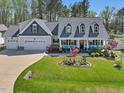 A well-kept two-story house with a lush green lawn and a three car garage at 49 Everwood Dr, Four Oaks, NC 27524