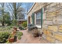 Unique stone exterior with green shutters, showing a view of the patio and garden area around the house at 4914 Western Blvd, Raleigh, NC 27606