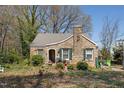 Charming stone cottage with green shutters and a unique architectural design, surrounded by lush greenery at 4914 Western Blvd, Raleigh, NC 27606