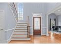 Grand foyer with a staircase, beautiful hardwood floors, and a decorative front door at 506 Rose Point Dr, Cary, NC 27518