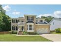 Charming two-story brick home with a manicured lawn and an attached two-car garage at 5144 Pinehall Wynd, Raleigh, NC 27604