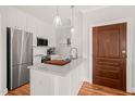 Well-equipped kitchen with white cabinetry, marble countertops, stainless steel appliances, and modern lighting at 605 Smedes Pl # A, Raleigh, NC 27605