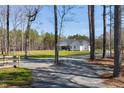 Expansive front yard with a long driveway leading to a stunning farmhouse at 6480 Beaver Creek Rd, New Hill, NC 27562