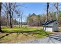 Scenic front yard featuring a storage shed and a view of the charming white farmhouse at 6480 Beaver Creek Rd, New Hill, NC 27562