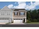 Charming townhome exterior featuring stone accents, a two-car garage, and landscaping that enhances the curb appeal at 6960 Doddridge Ln # 15, Cary, NC 27519