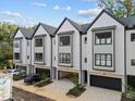 Attractive townhome exterior with well-manicured landscaping and individual garages at 810 Maple Berry Ln # 105, Raleigh, NC 27607