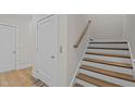 Bright hallway with wood stairs, white risers, and elevator entrance at 810 Maple Berry Ln # 105, Raleigh, NC 27607