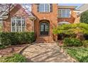 Inviting front entrance with a black double door, brick steps and manicured shrubbery at 9320 Teton Pines Way, Raleigh, NC 27617
