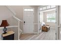 Welcoming foyer with elegant staircase, stylish flooring, and a glimpse into a cozy sitting room at 1008 Garden Square Ln, Morrisville, NC 27560