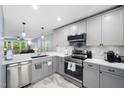 Updated kitchen featuring stainless steel appliances, quartz countertops, and modern pendant lighting at 101 Hunting Chase # 2B, Cary, NC 27513