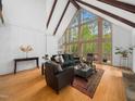 Bright living room featuring large windows, exposed ceiling beams, and wood floors, offering a seamless connection with nature at 109 Barcliff Ter, Cary, NC 27518