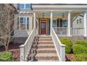 Stairs lead up to a covered porch with white columns and a bright red front door at 113 Bennett Mountain Trce, Chapel Hill, NC 27516