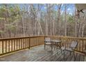 Outdoor deck with seating, providing a relaxing space surrounded by a wooded area at 125 Camden Dr, Youngsville, NC 27596