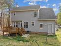 View of the rear exterior with a wooden deck and backyard, highlighted by gray siding and updated windows at 125 Camden Dr, Youngsville, NC 27596