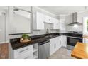 Bright kitchen features stainless steel appliances, black countertops, and white cabinets at 1306 Ed Cook Rd, Durham, NC 27703