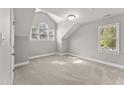 Neutral bedroom featuring light carpet, an arched window, and bright natural light at 1426 Quarter Pt, Raleigh, NC 27615