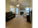Cozy living room featuring a fireplace, ceiling fan, and comfortable seating at 144 Gremar Dr, Holly Springs, NC 27540