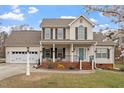 Inviting two-story home with a manicured lawn, blooming tree, and attached garage; offers comfort and curb appeal at 15 Longwood Dr, Youngsville, NC 27596