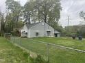 View of a fenced in backyard with mature trees, a detached garage, and a gray exterior at 1609 Evergreen St, Durham, NC 27703