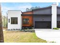Stylish home exterior featuring a white brick accent, wood detail, and black garage door at 1621 Bruce Circle, Raleigh, NC 27604