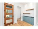 Bright foyer with wood floors, blue cabinets, and a modern wood door with glass at 1621 Bruce Circle, Raleigh, NC 27604