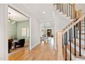 Spacious hallway featuring hardwood floors, access to living areas, and a view of the staircase at 1629 Montvale Grant Way, Cary, NC 27519